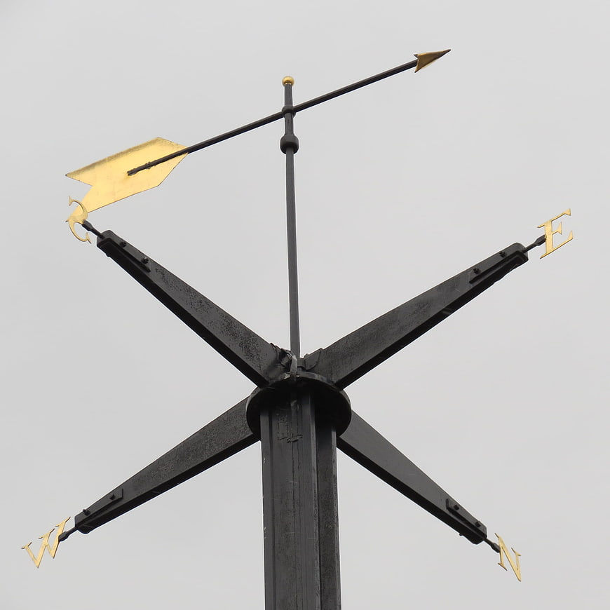 Black and Gold Compass Rose Weather Vane Against Overcast Sky