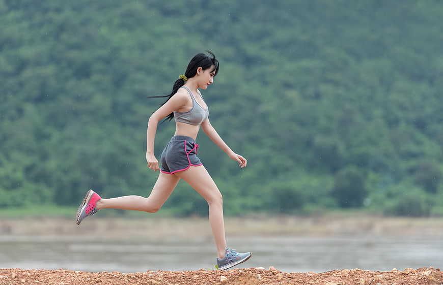 Young woman running outdoors on a gravel path