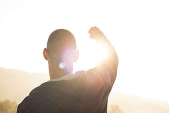 Man Raising Fist In Victory At Sunset