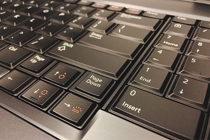 Close-up of black laptop keyboard with orange function keys