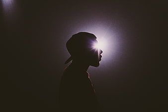 Silhouette of man with light shining through eye