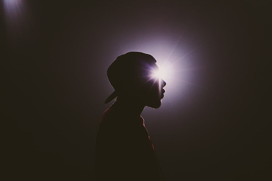Silhouette of man with light shining through eye