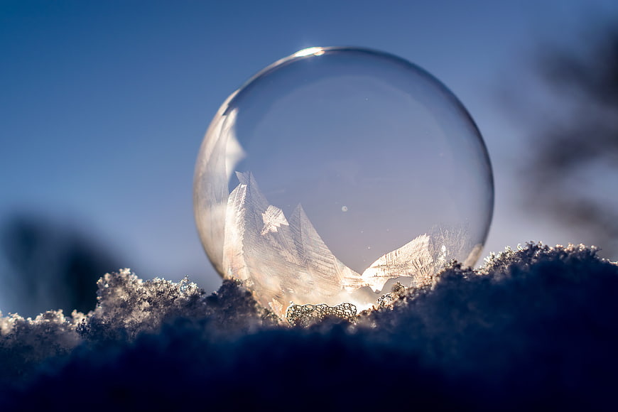 Frozen Soap Bubble with Ice Crystals on Snow in Winter