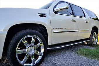Side view of white Cadillac Escalade ESV with chrome wheels