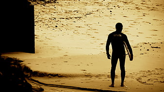Silhouette of Surfer Walking on Sandy Beach