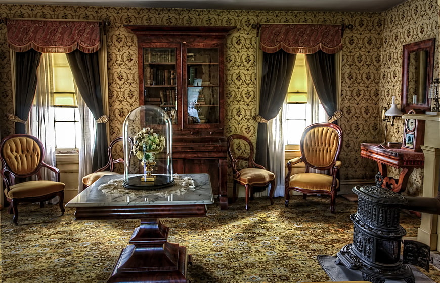 Vintage Victorian parlor with ornate furniture and floral wallpaper