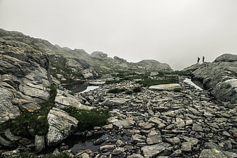 Hikers on Rocky Mountain Ridge in Foggy Weather