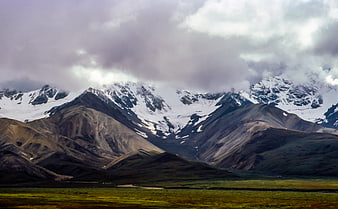 Dramatic Snow-Capped Mountain Range with Green Valley