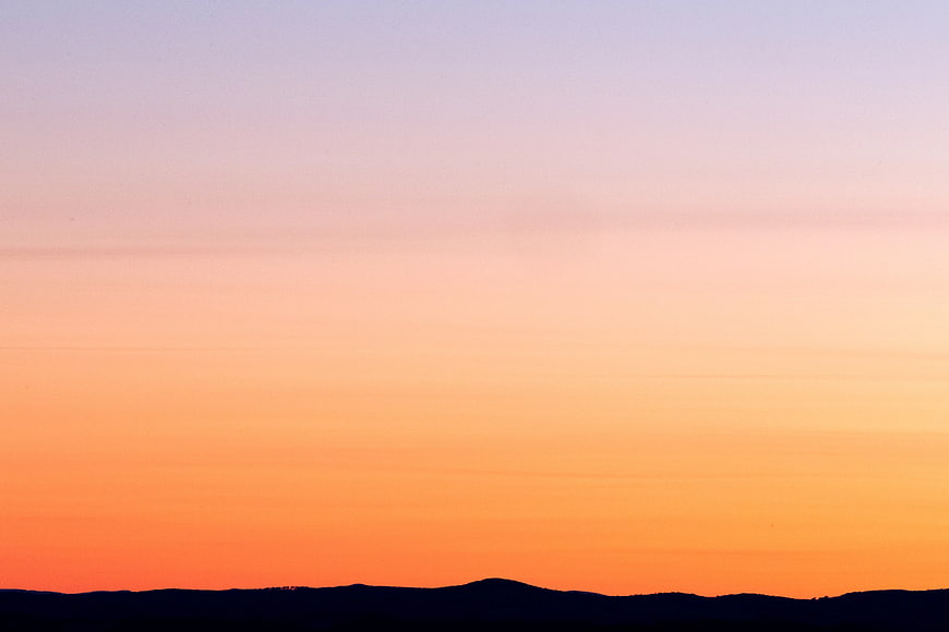 Gradient Sunset Sky Over Silhouette Hills