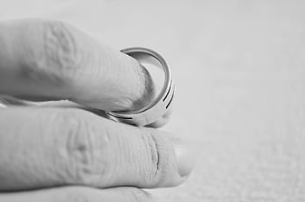 Black and white close-up of a hand holding a silver ring