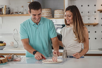 Happy couple cooking breakfast together in modern kitchen