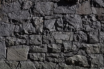 Textured gray stone wall background with rough surface