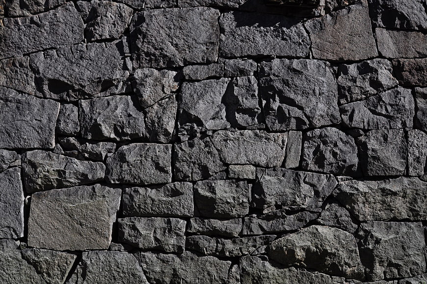 Textured gray stone wall background with rough surface