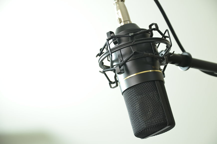 Professional condenser microphone in shock mount on white background