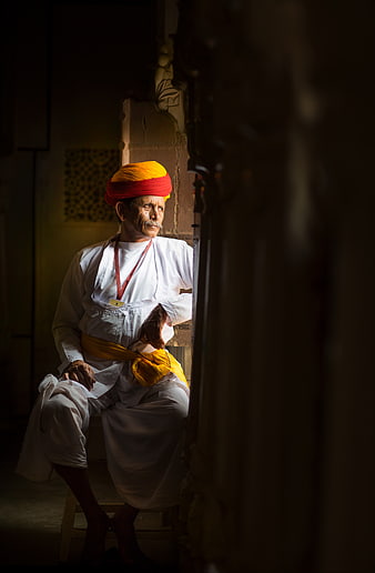 Indian man in traditional turban sitting in doorway