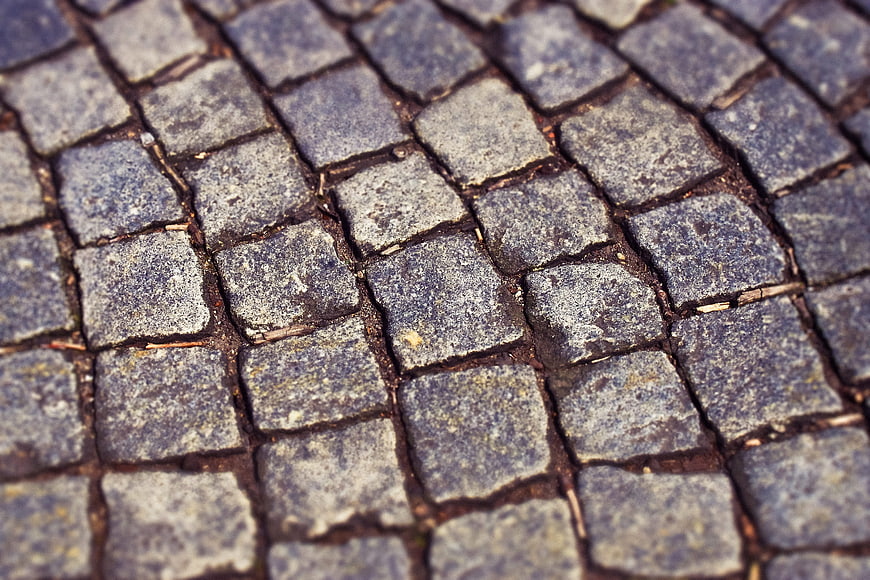 Close-up texture of old gray cobblestone pavement