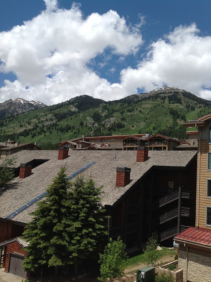 Mountain resort architecture with green slopes and blue sky