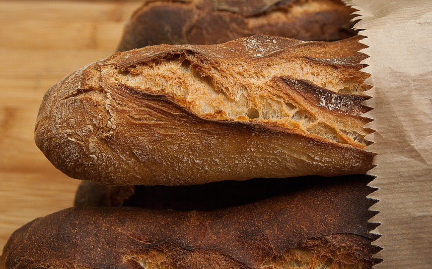 Freshly Baked Rustic Sourdough Bread Loaves on Wooden Table