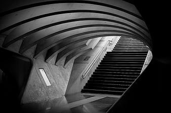 Black and white architectural photo of curved concrete subway stairs