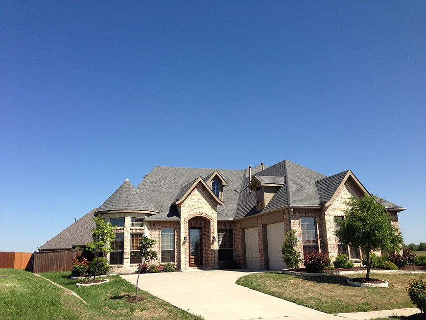 Modern suburban house with stone facade and blue sky