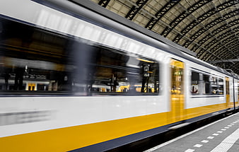 Motion blur of yellow and white train at station platform