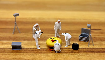 Miniature police forensic team investigating emoji crime scene