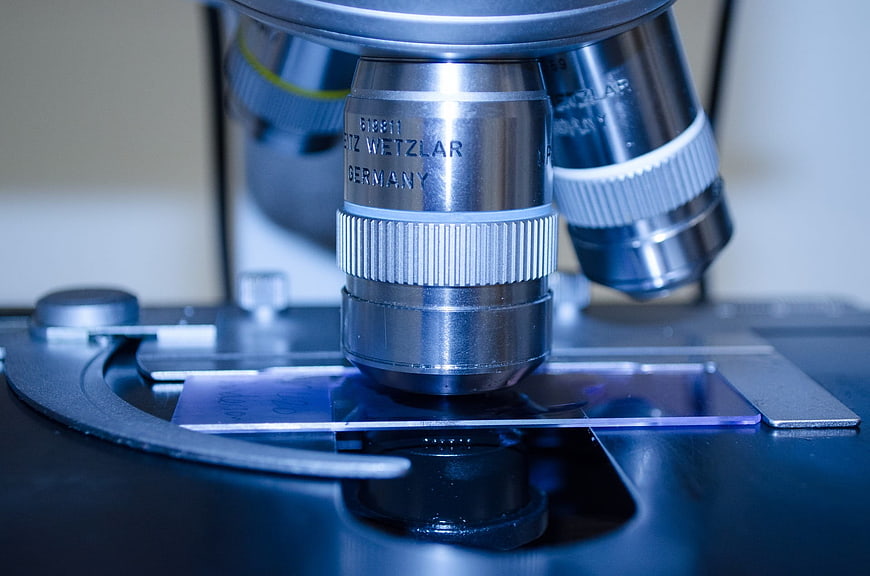 Close-up of microscope objective lens on glass slide