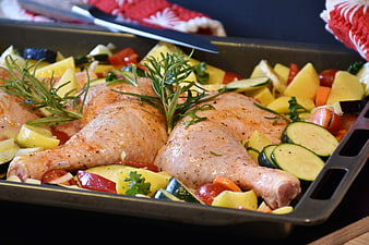 Raw Chicken Legs with Vegetables on Baking Sheet