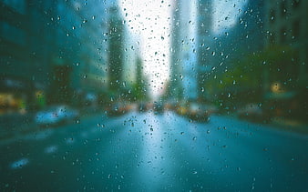Raindrops on Glass Window with Blurred City Street Background