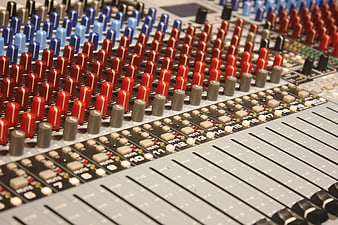 Close-up of professional audio mixing console with colorful knobs