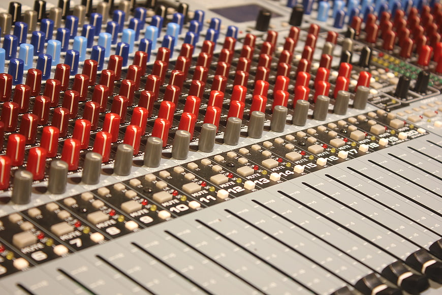 Close-up of professional audio mixing console with colorful knobs