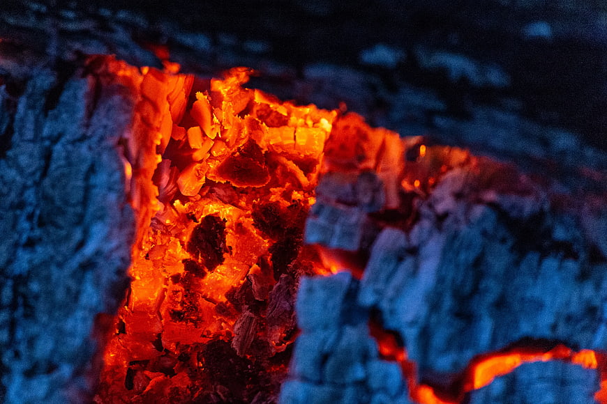 Close-up of glowing embers and burning firewood