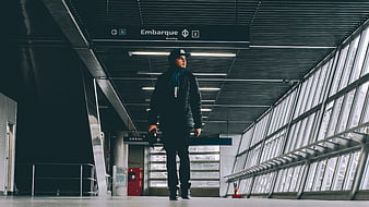 Young man walking in modern airport terminal