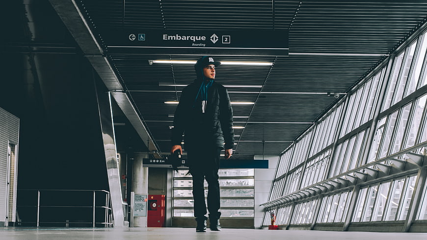 Young man walking in modern airport terminal