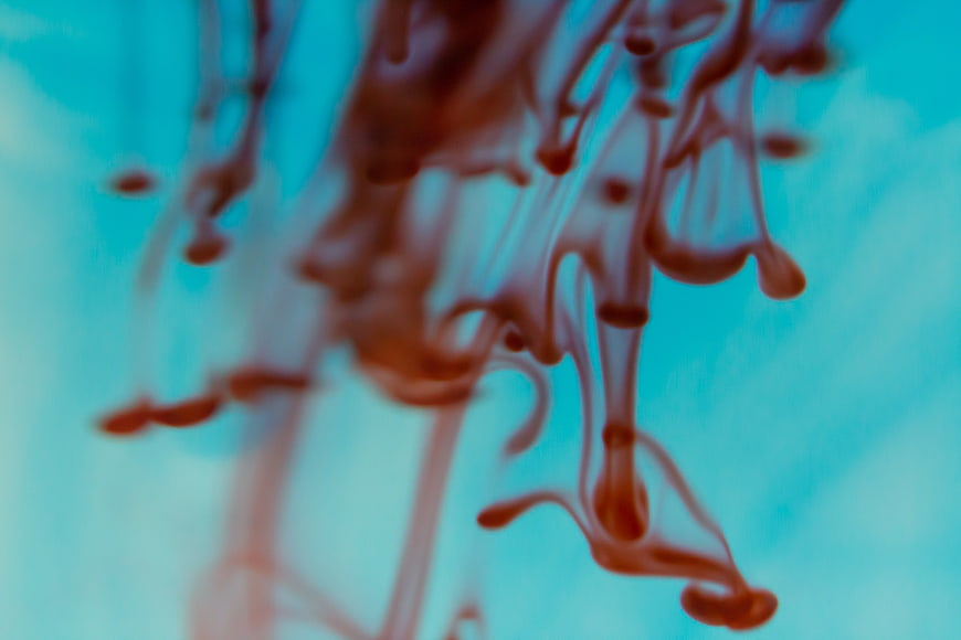 Abstract Red Ink Swirling in Blue Water