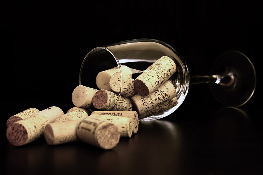 Wine Corks Spilling from Glass on Black Background