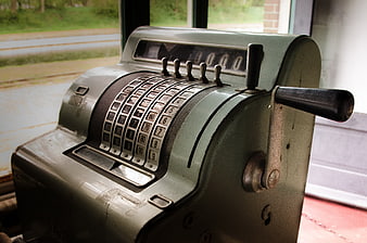 Vintage mechanical cash register by window