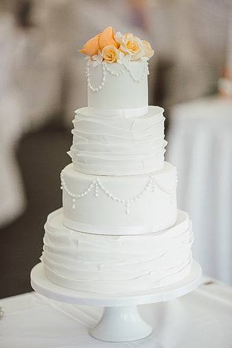 Elegant Four-Tier White Wedding Cake with Orange Roses