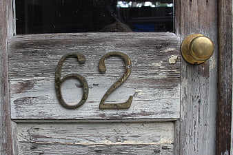 Weathered Wooden Door with Brass Number 62 and Doorknob
