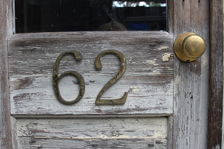 Weathered Wooden Door with Brass Number 62 and Doorknob
