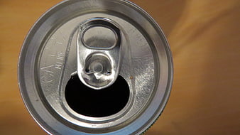 Top view of opened aluminum soda can on wooden table