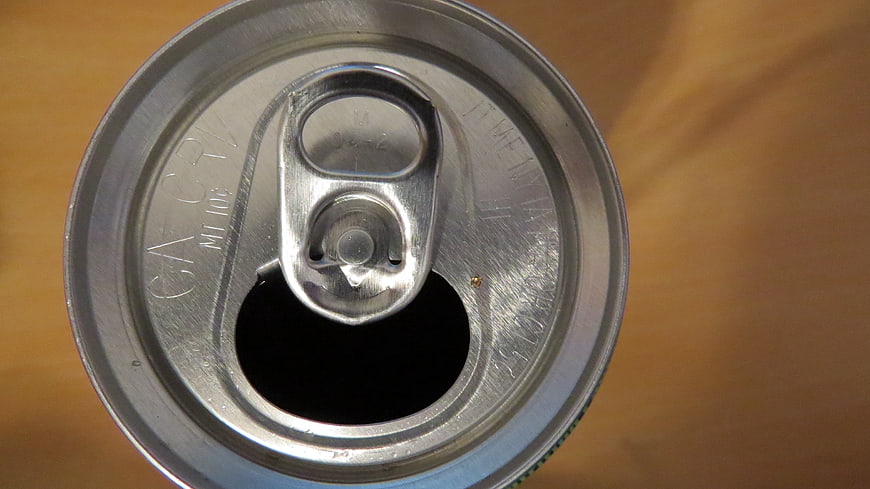 Top view of opened aluminum soda can on wooden table
