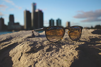 Sunglasses on Rock with City Skyline Background