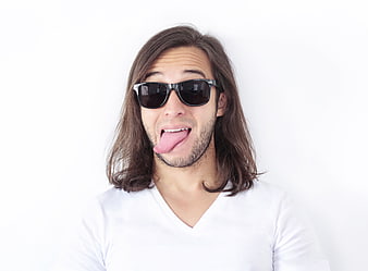 Funny man with long hair sticking tongue out wearing sunglasses
