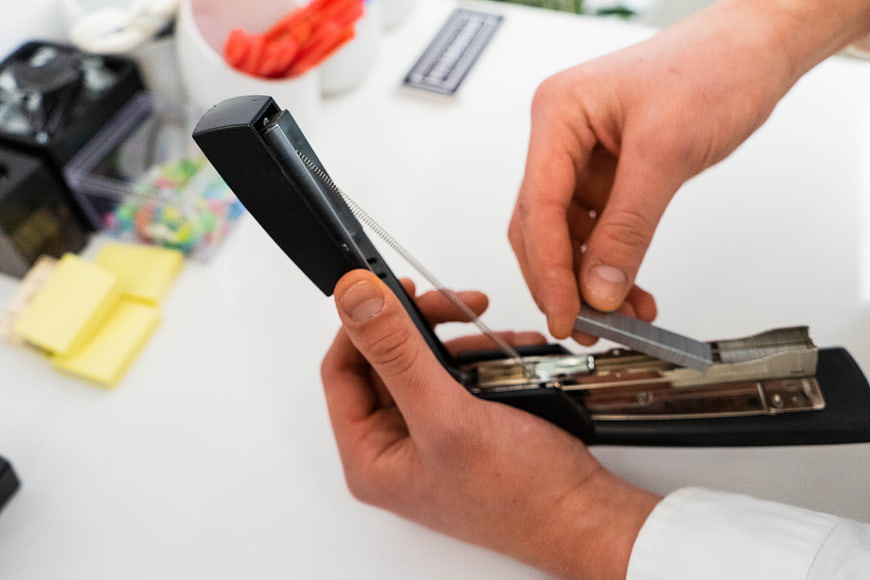 Hands Loading Staples into Office Stapler