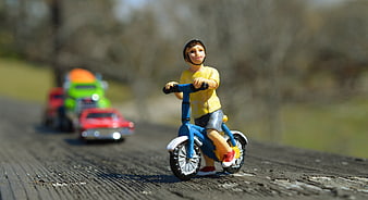 Toy Boy Cyclist With Helmet And Traffic Cars On Wooden Surface