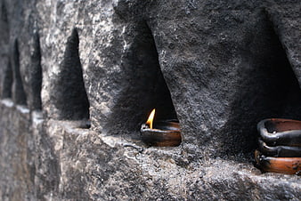 Traditional oil lamp flame in ancient stone niche