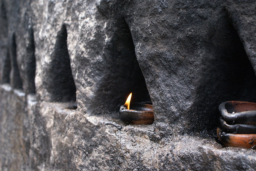Traditional oil lamp flame in ancient stone niche