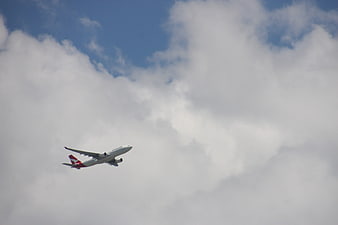 Qantas airplane ascending into cloudy blue sky