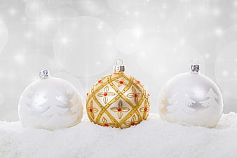 White and Gold Christmas Ornaments on Snow with Sparkling Background